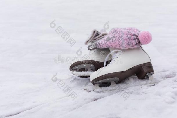 一副关于白色的冰溜冰鞋和同样地粉红色的斯堪的纳维亚的绒球帽子采用