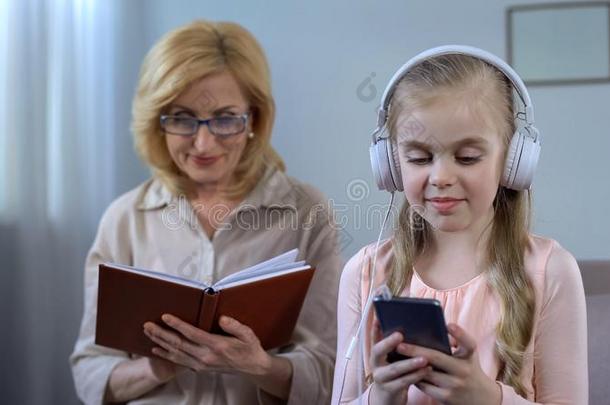 小的女孩采用耳机listen采用g向书记录上了年纪的女人