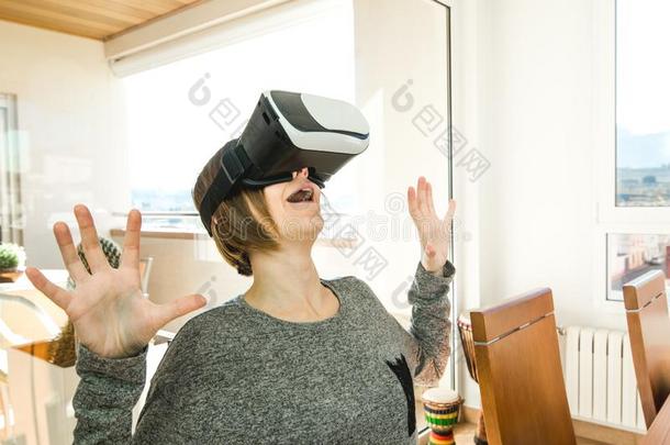 兴奋的和幸福的年幼的女人使人疲乏的VirtualReality虚拟现实眼镜.观念关于野狗