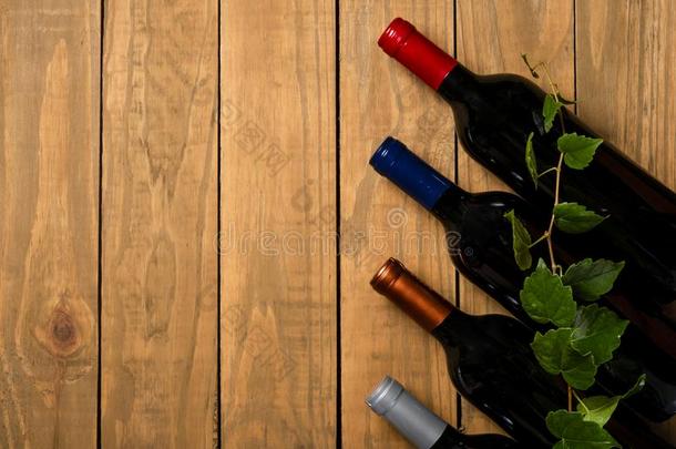 几个的瓶子关于葡萄酒和藤树叶向木制的背景.向