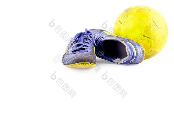 老的被损坏的合成的五人制的足球比赛室内足球和鞋子和老的黄色的五人制的足球比赛室内足球balancing平衡