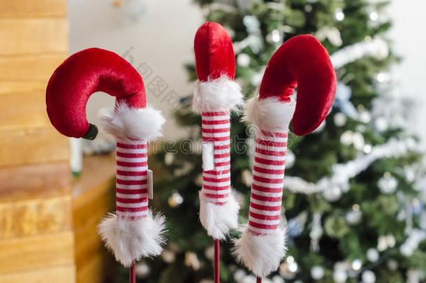 红色的和白色的小精灵木头支架和圣诞节树背景