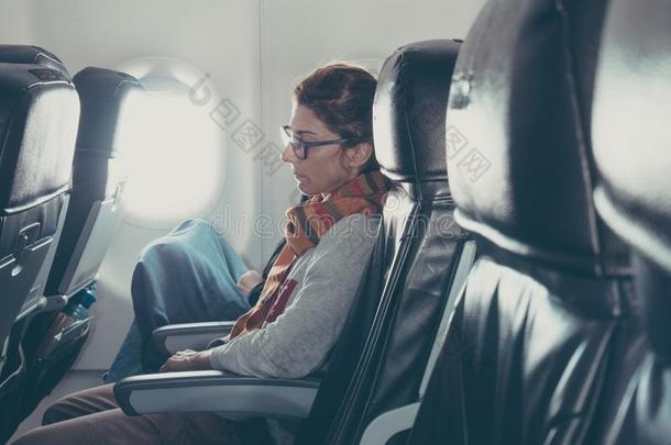 女人睡眠在期间同行的在旁边飞机,旅行假期集中起来的