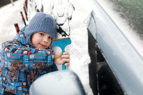 男孩刮雪从车辆