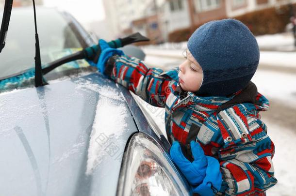 男孩疾驰的雪从落下汽车