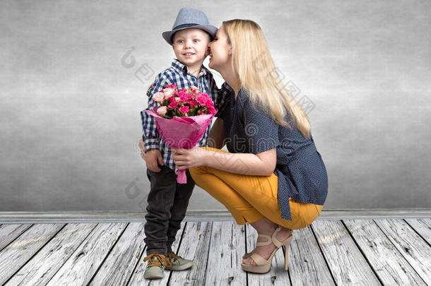 小的儿子给予他的被热爱的母亲一be一utiful花束关于粉红色的英语字母表的第18个字母