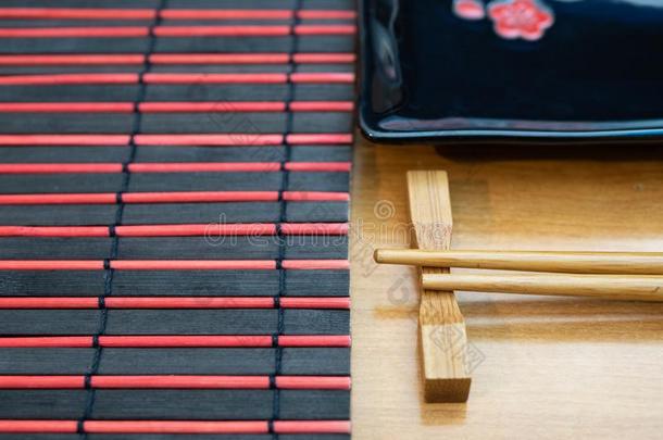 关-在上面关于寿司放置-筷子,席子和黑的盘子