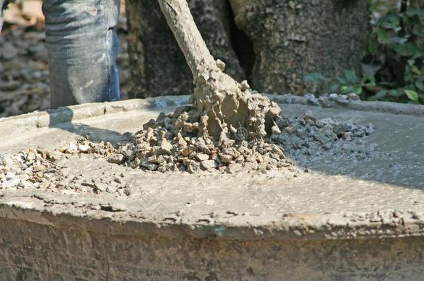 员工使用指已提到的人锄头向混合具体的,沙,岩石和水采用Thailand泰国