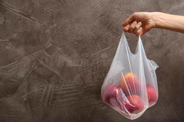 女人佃户租种的土地塑料制品袋和<strong>苹果</strong>向<strong>灰色</strong>背景