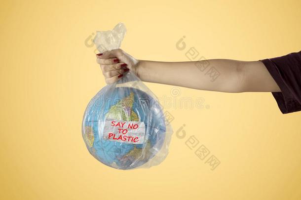 未知的女人保存塑料制品袋和地球球