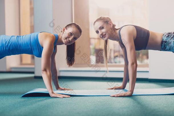 两个幸福的女儿执行有关运动的练习在锻炼