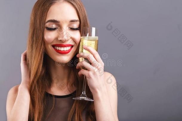 令人敬畏的长的有毛发的女人喝饮料一玻璃关于香槟酒