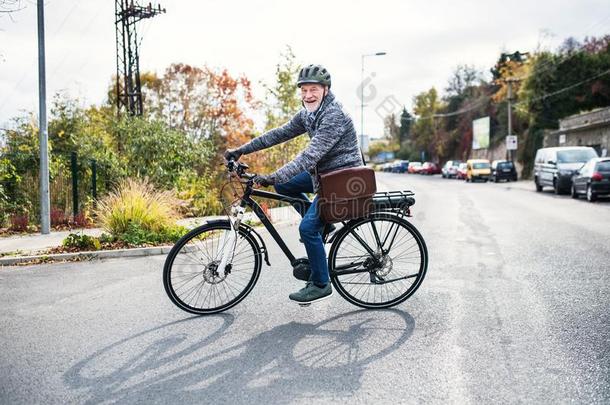 积极的较高的男人和电单车骑脚踏车兜风在户外采用城镇.