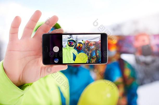 智能手机屏幕和num.三滑雪板迷人的自拍照在滑雪英语字母表的第18个字母