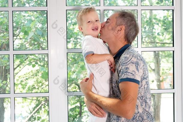 幸福的男人接吻的值得崇拜的儿子采用脸颊