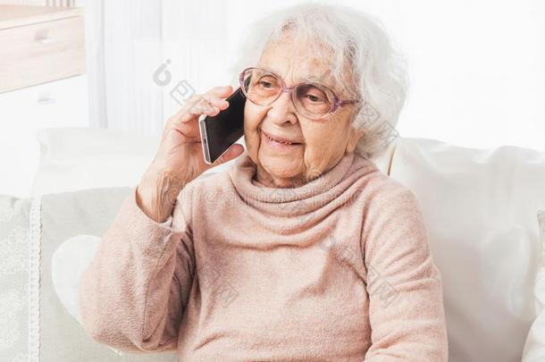 伟大的-祖母讲话在旁边智能手机