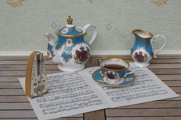 英语茶杯和茶杯托,茶壶和乳霜n.大罐,和一节拍器