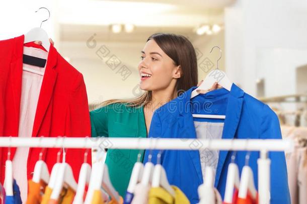 幸福的女人挑选衣服在衣服商店
