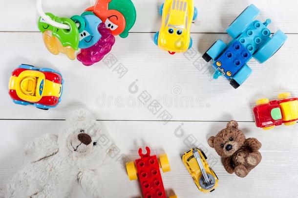 富有色彩的小孩玩具向白色的木制的背景