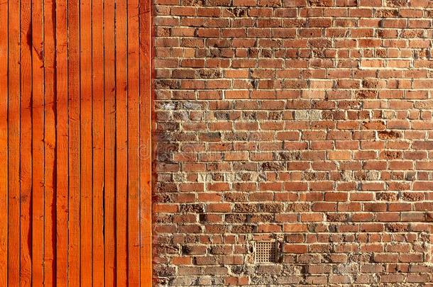 明亮的红色的木材栅栏紧接在后的向一老的砖墙
