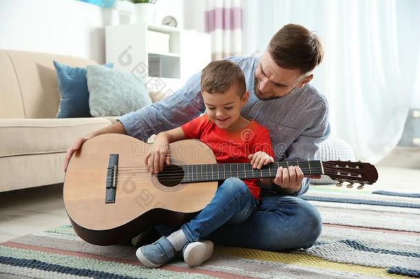 父亲教学他的小的儿子向比赛吉他