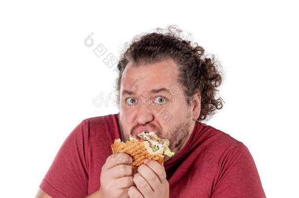 有趣的肥的男人吃汉堡包.快的食物,很不健康吃.太好了