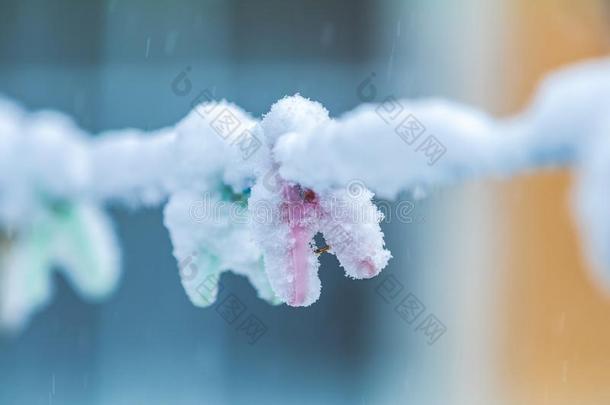 冬在户外向一粗绳h一nging晒衣绳上夹衣服之夹子撕在旁边雪