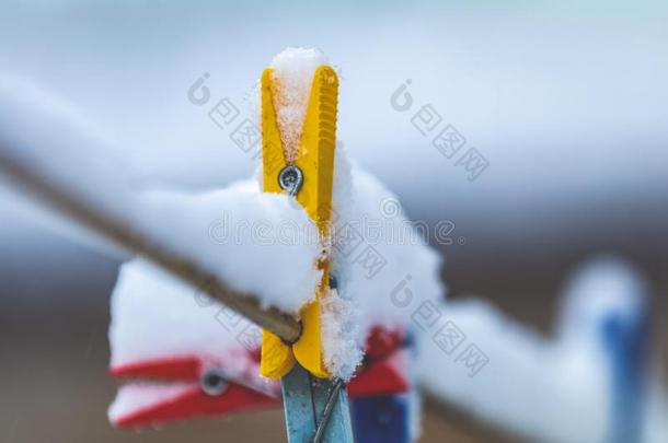 冬在户外向一粗绳h一nging晒衣绳上夹衣服之夹子撕在旁边雪