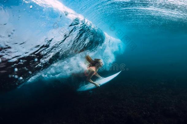 有魅力的冲浪运动员女人潜水在水中的,在下面桶波浪采用balls球