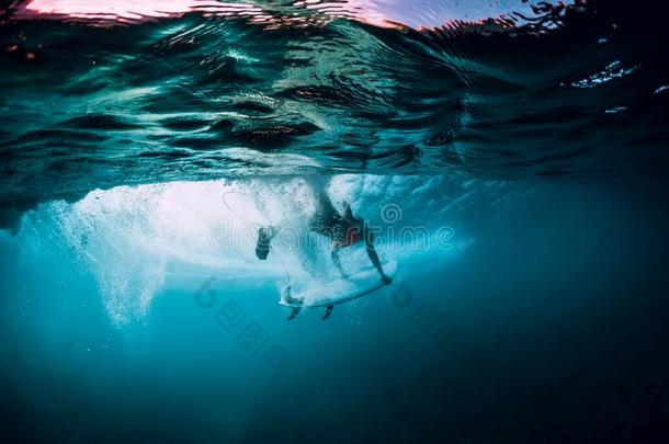 有魅力的冲浪运动员女人潜水在水中的和在下面桶波浪