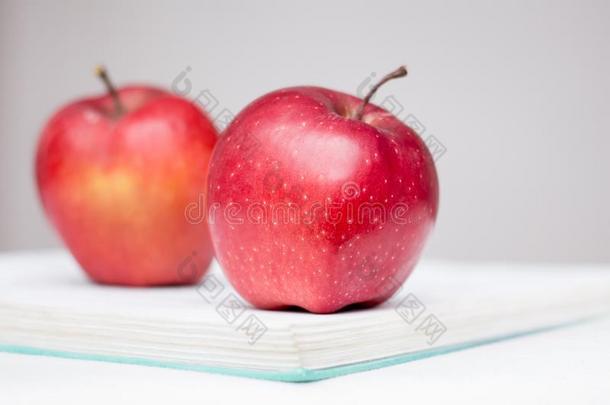 美味的多汁的红色的苹果躺向一<strong>展开</strong>的<strong>书</strong>.有用的美味的folio编页码
