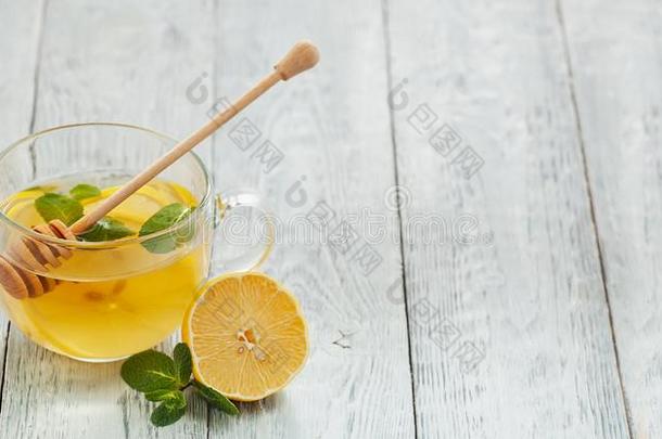 玻璃杯子关于热的茶水和柠檬,薄荷和蜂蜜.健康的喝