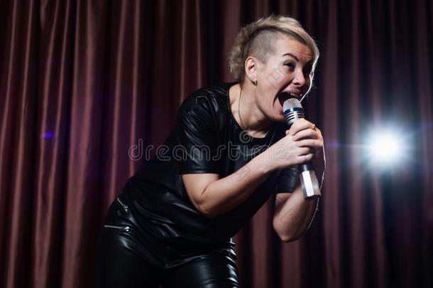 女人唱歌向阶段采用指已提到的人microph向e卡拉OK向指已提到的人后台