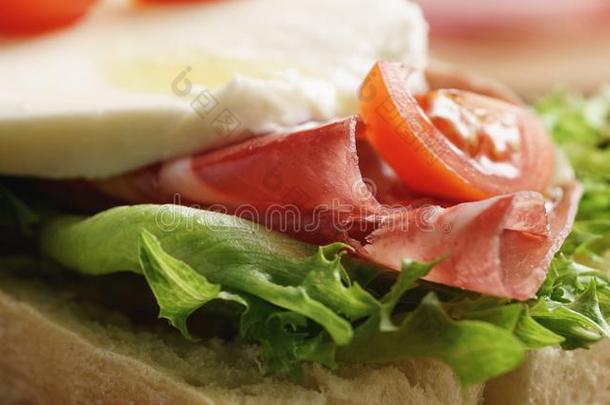 特写镜头关于敞开的三明治和意大利熏火腿,意大利干酪和番茄
