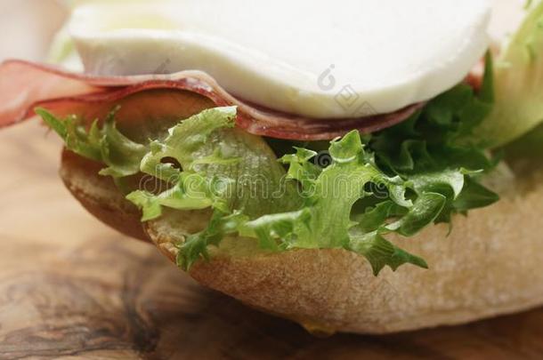 特写镜头关于敞开的三明治和意大利熏火腿,意大利干酪和番茄
