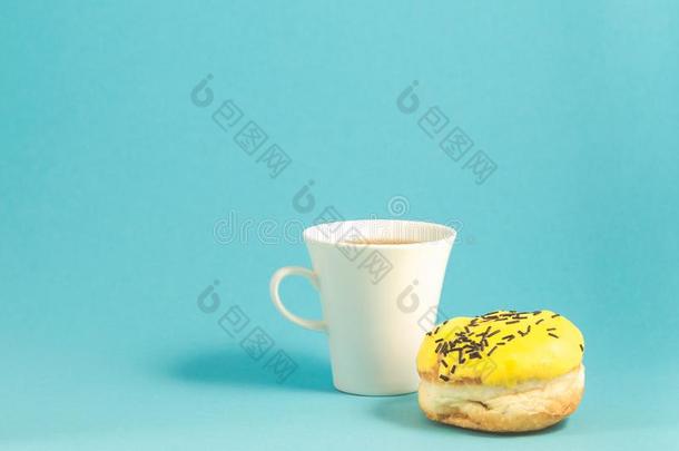 油炸圈饼和咖啡杯子隔离的向蓝色背景/D向ut采用黄色的