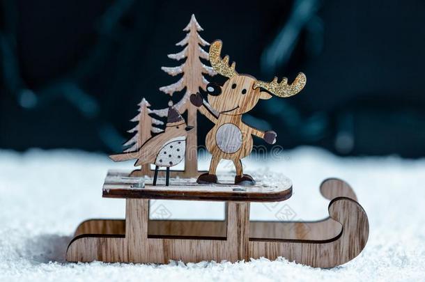 木制的雪橇和鹿和圣诞节树向雪向焦外成像背