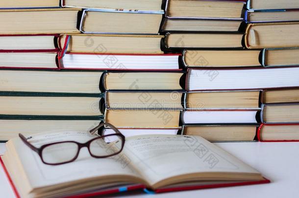 精装书书向白色的木制的表,敞开的书和眼镜,警察