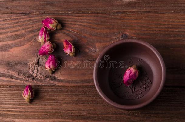 指已提到的人茶水杯子和det.一些茶水玫瑰芽是向指已提到的人木制的表