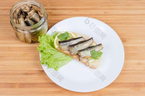 敞开的三明治和防腐的熏制的鲱鱼属的小鱼和罐子和鲱鱼属的小鱼