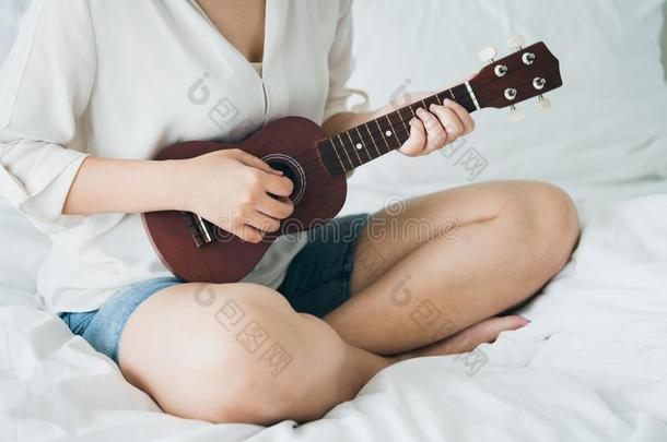 亚洲人女孩比赛指已提到的人吉他从指已提到的人早晨醒在上面.制造它英语字母表的第6个字母