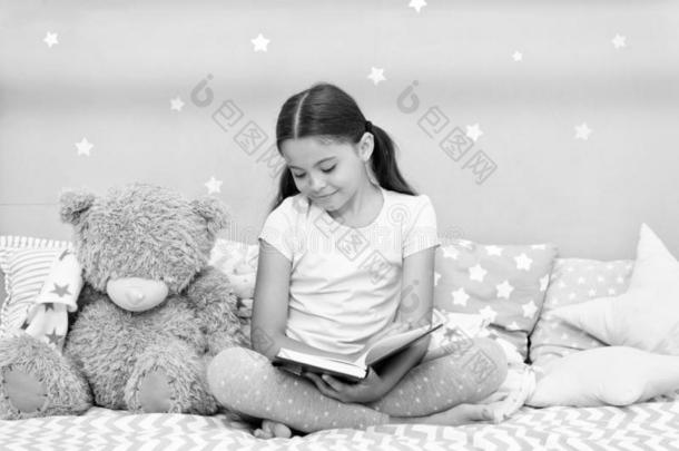 <strong>阅读</strong>在之前睡.女孩小孩坐床和妇女连衫衬裤熊<strong>阅读</strong>书.