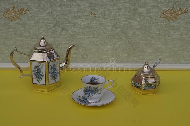 英语茶杯,茶杯托,银-镀金的茶壶,食糖碗和漂亮、可爱的姑娘