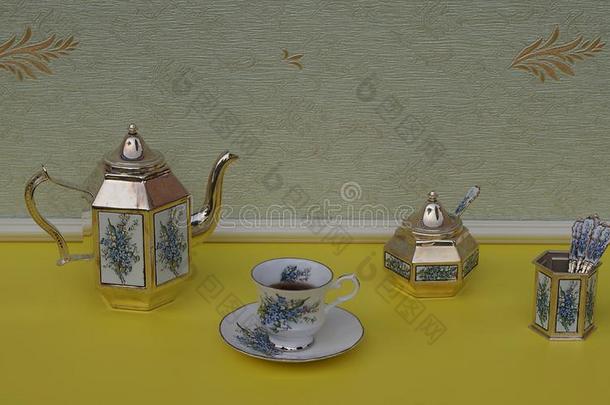 英语茶杯,茶杯托,银-镀金的茶壶,食糖碗和漂亮、可爱的姑娘