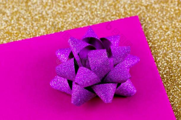 闪耀的淡紫色的赠品弓向淡紫色的卡片.