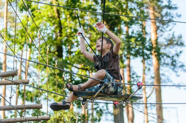 男孩经过的缆绳路采用极端的冒险活动粗绳公园