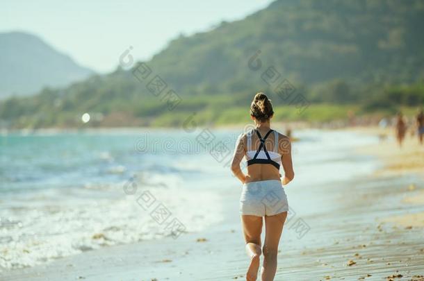 年幼的女人慢跑锻炼者向洋岸采用even采用gjogg采用g