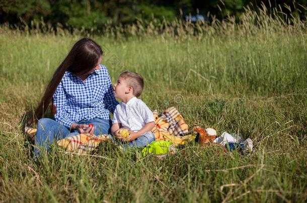 母亲和年幼的儿子吃在一野餐郊游在户外帐篷