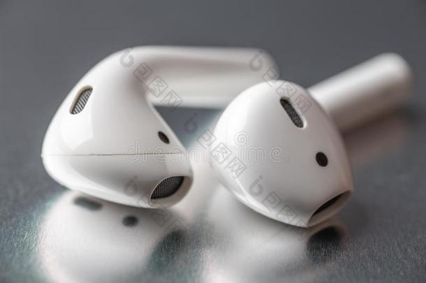 白色的不用电线的蓝牙耳机或耳机向银后面