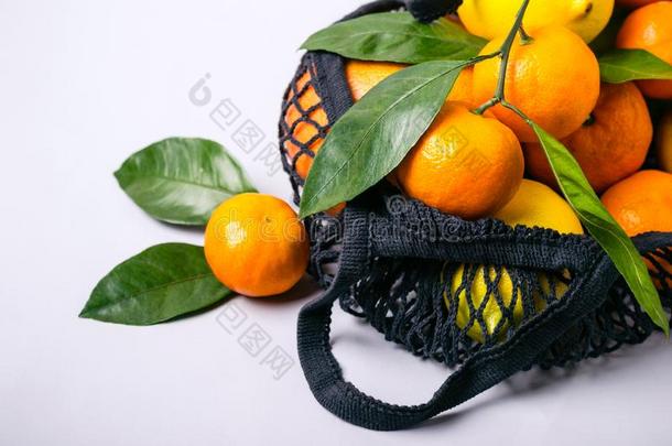 橘子和柠檬采用纺织品袋向灰色背景.健康的